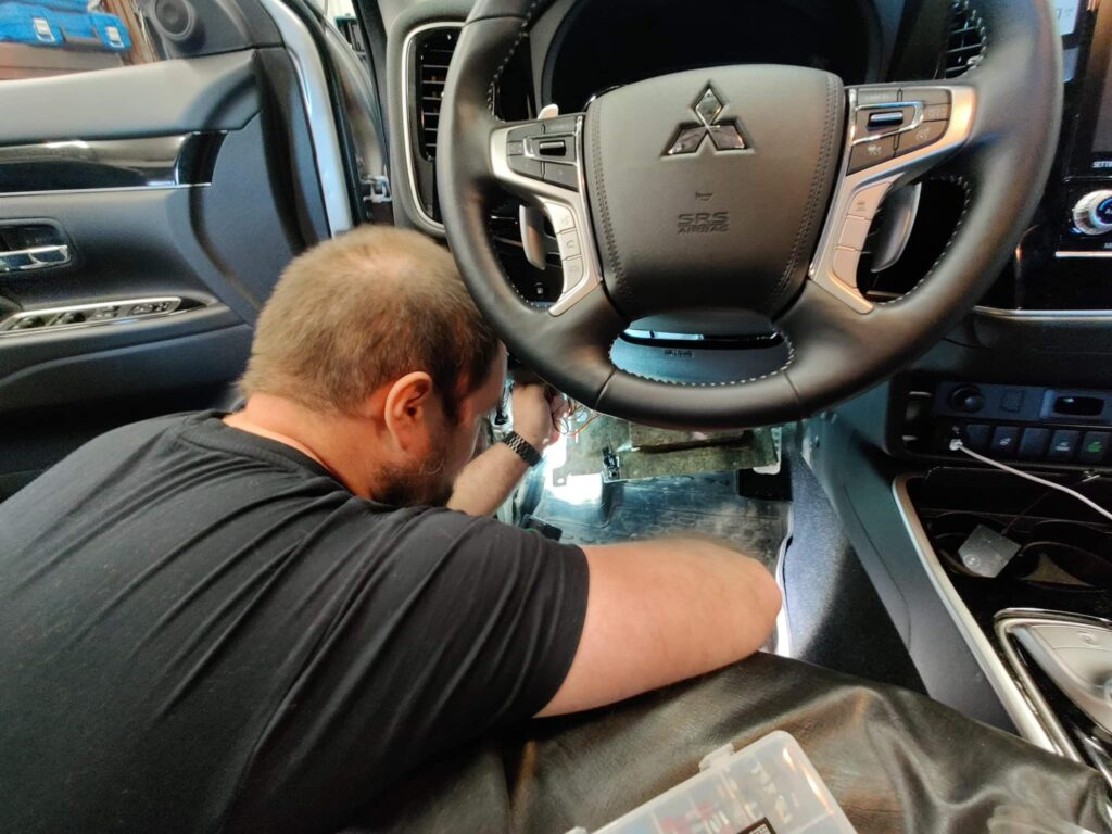 Mand reparerer bilens instrumentbræt